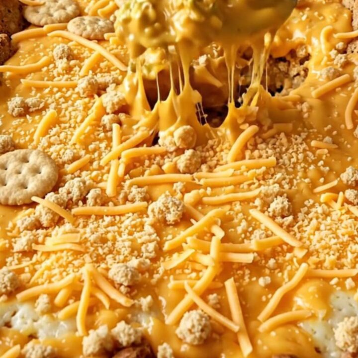 A top-down view of a rectangular baking dish filled with broccoli covered in creamy cheddar sauce and a cracker crust.