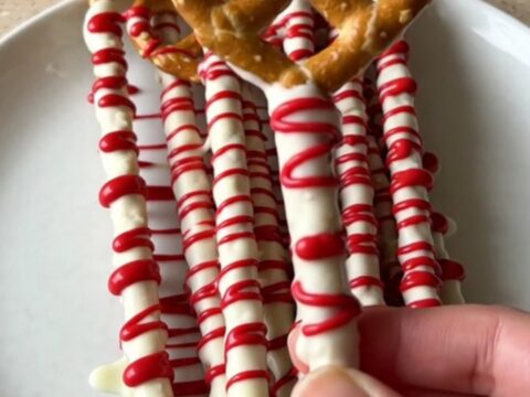 A plate of bloody vampire pretzel rods with white chocolate and red drizzle.