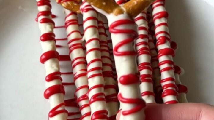 A plate of bloody vampire pretzel rods with white chocolate and red drizzle.