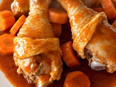 Slow cooker Polynesian chicken drumsticks with carrots and green peppers in a savory red sauce.