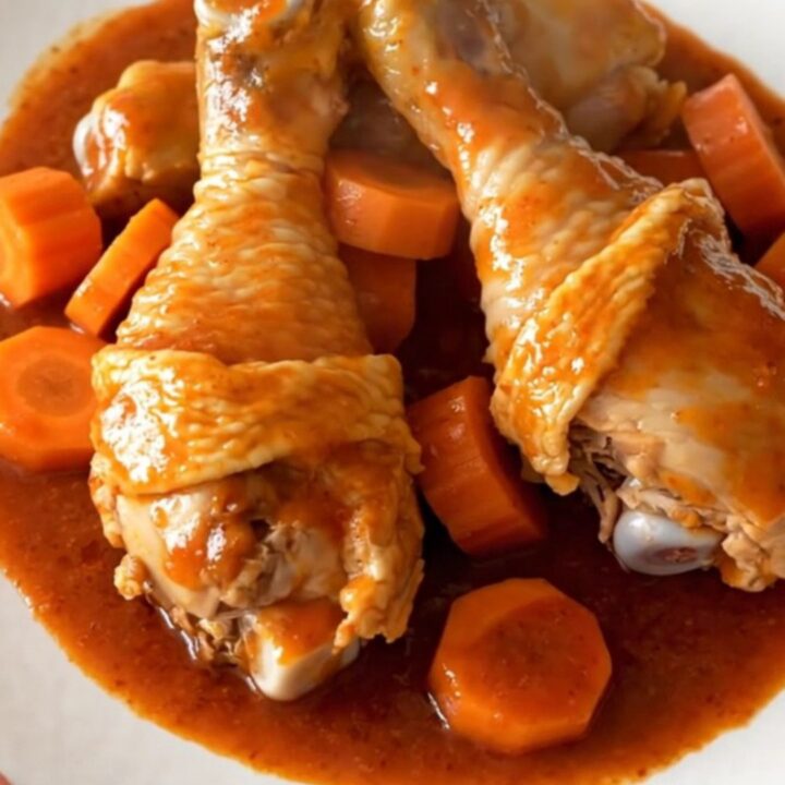 Slow cooker Polynesian chicken drumsticks with carrots and green peppers in a savory red sauce.