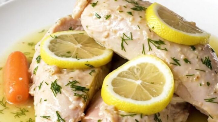 A plate of cooked, tender turkey breast tenderloins with baby carrots and a lemon dill sauce.