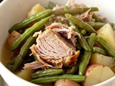 A hearty bowl of slow cooker smoked turkey with green beans and potatoes in a savory broth.