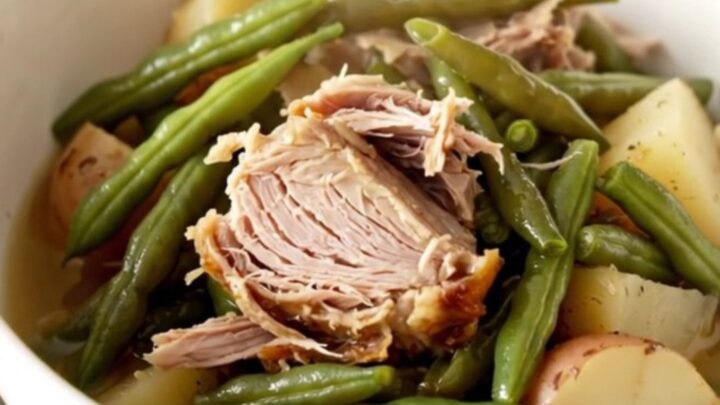 A hearty bowl of slow cooker smoked turkey with green beans and potatoes in a savory broth.