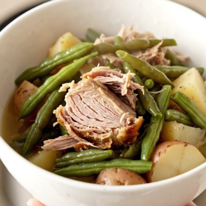 A hearty bowl of slow cooker smoked turkey with green beans and potatoes in a savory broth.