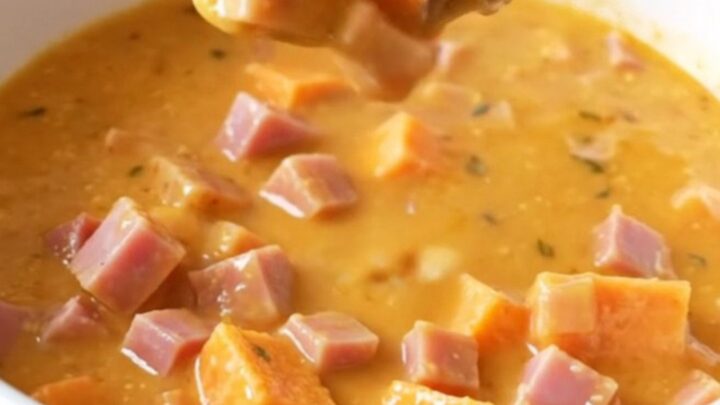 A rustic bowl of creamy maple ham and sweet potato chowder with visible chunks of ham and soft potatoes.