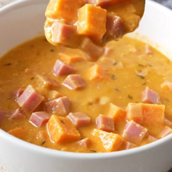 A rustic bowl of creamy maple ham and sweet potato chowder with visible chunks of ham and soft potatoes.