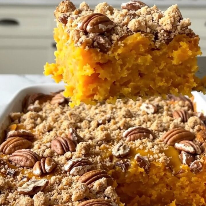 A freshly baked pecan streusel sweet potato casserole in a rectangular ceramic dish, showing a golden brown crust.