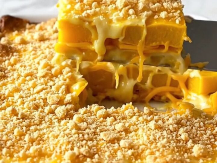 A golden-brown Southern yellow squash casserole in a white ceramic dish.