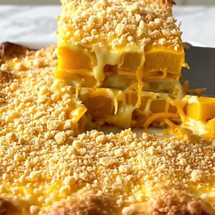 A golden-brown Southern yellow squash casserole in a white ceramic dish.