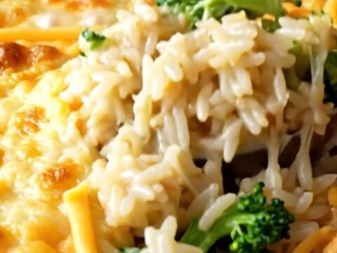 A cheesy broccoli rice casserole in a white baking dish with golden melted cheese on top.