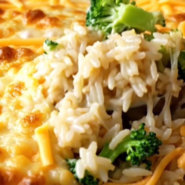 A cheesy broccoli rice casserole in a white baking dish with golden melted cheese on top.