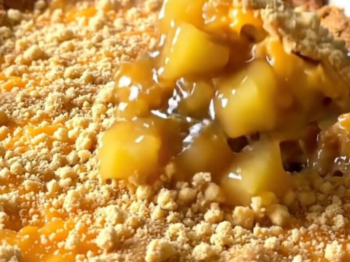A top-down view of a vintage pineapple cheddar casserole in a white dish with a golden, crispy cracker crust.