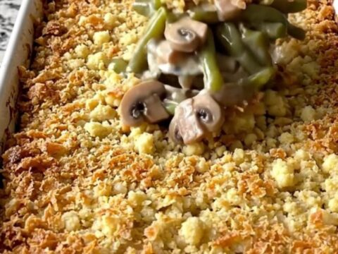 A top-down view of a rectangular baking dish filled with a creamy green bean casserole topped with golden brown stuffing.