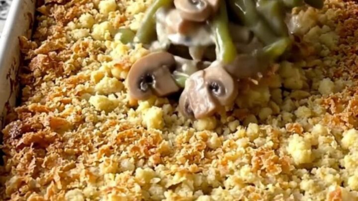 A top-down view of a rectangular baking dish filled with a creamy green bean casserole topped with golden brown stuffing.