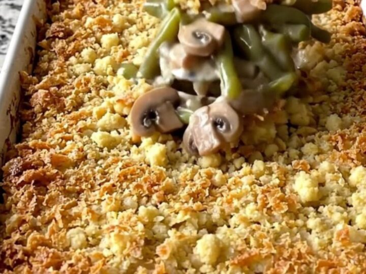A top-down view of a rectangular baking dish filled with a creamy green bean casserole topped with golden brown stuffing.
