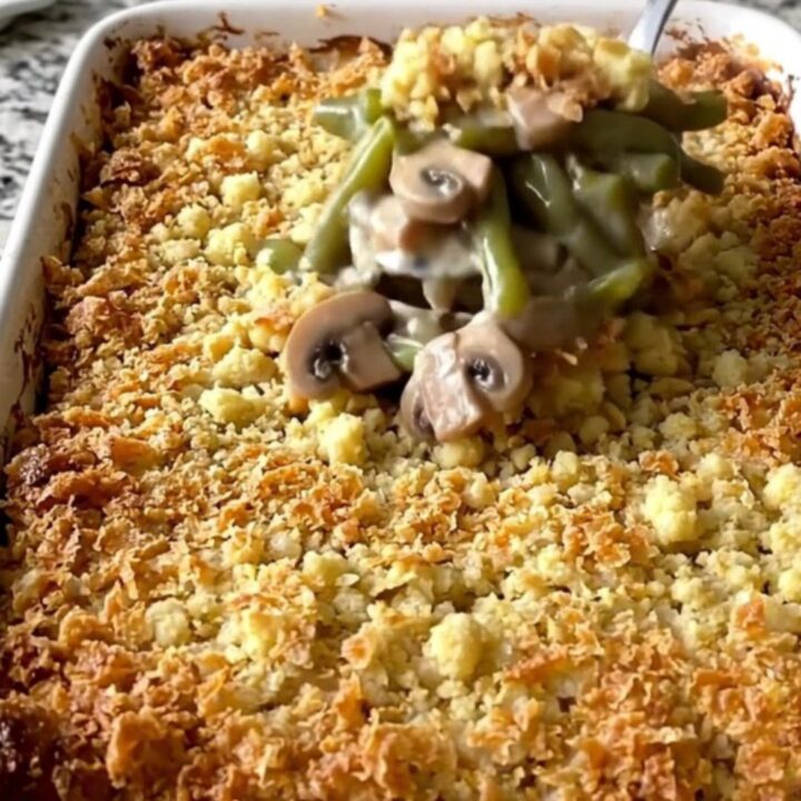 A top-down view of a rectangular baking dish filled with a creamy green bean casserole topped with golden brown stuffing.