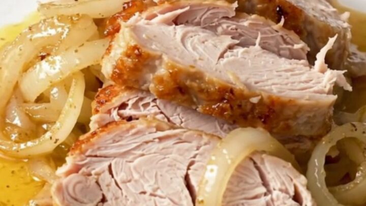 A close-up view of the slow-cooked Cajun butter turkey breast resting in a black slow cooker insert.