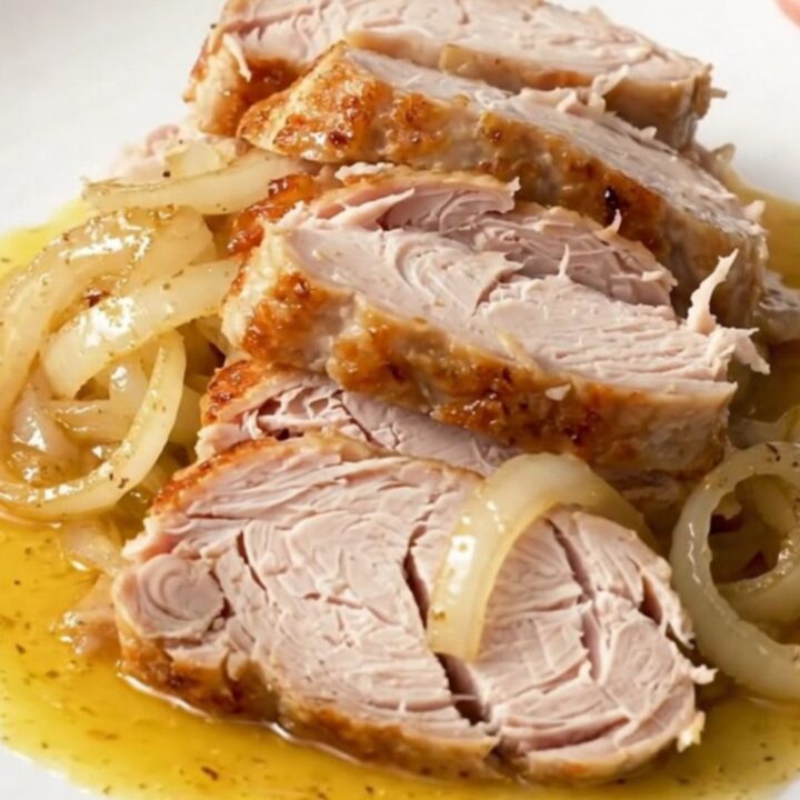 A close-up view of the slow-cooked Cajun butter turkey breast resting in a black slow cooker insert.