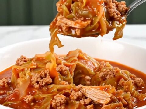 A close-up of a bowl of cabbage roll stew featuring ground turkey and chopped cabbage in a rich red tomato sauce.