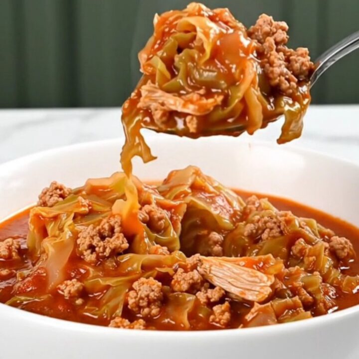 A close-up of a bowl of cabbage roll stew featuring ground turkey and chopped cabbage in a rich red tomato sauce.