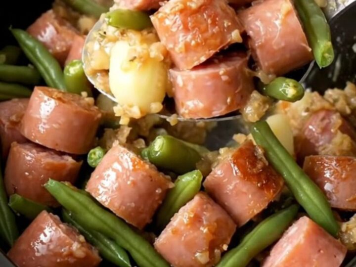 A hearty serving of slow-cooked Italian sausage, baby potatoes, and green beans in a savory herb butter sauce.