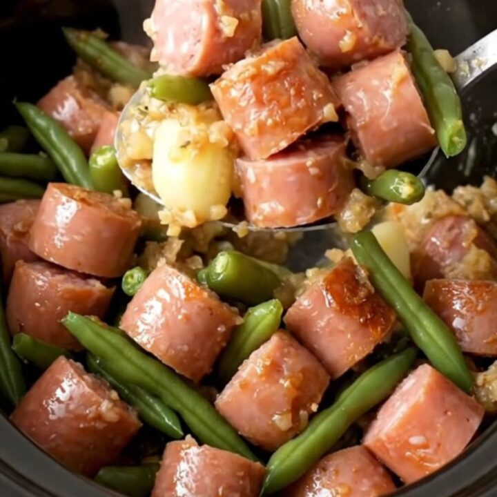 A hearty serving of slow-cooked Italian sausage, baby potatoes, and green beans in a savory herb butter sauce.