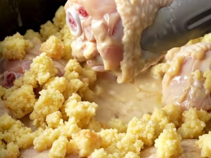A close-up of tender chicken drumsticks cooked with creamy stuffing in a slow cooker.