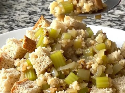 A rustic slow cooker filled with golden, herb-flecked bread stuffing prepared with sage and brown butter.