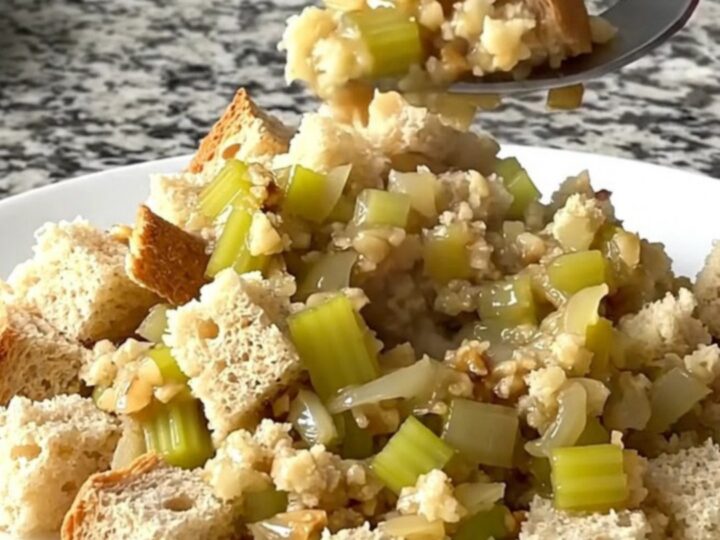A rustic slow cooker filled with golden, herb-flecked bread stuffing prepared with sage and brown butter.