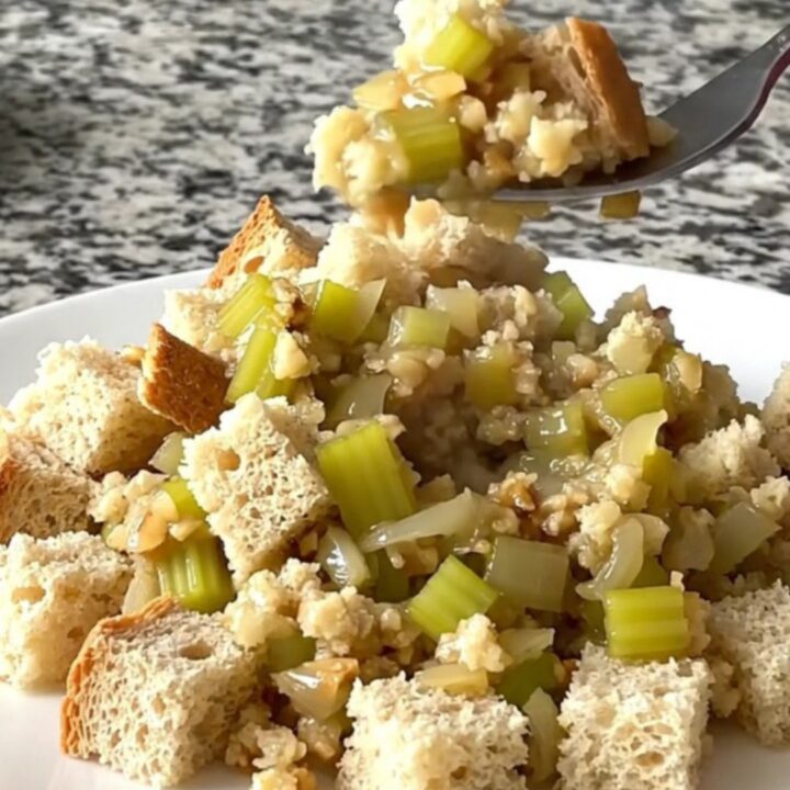 A rustic slow cooker filled with golden, herb-flecked bread stuffing prepared with sage and brown butter.