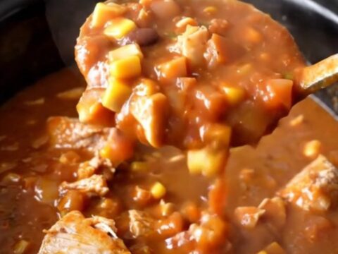 A hearty bowl of slow cooker turkey taco potato stew with visible chunks of potato, corn, and beans.