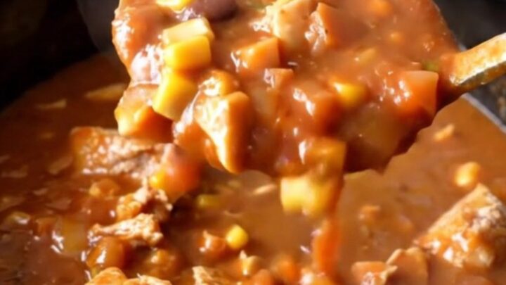 A hearty bowl of slow cooker turkey taco potato stew with visible chunks of potato, corn, and beans.