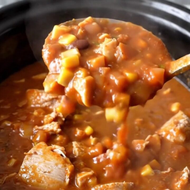 A hearty bowl of slow cooker turkey taco potato stew with visible chunks of potato, corn, and beans.