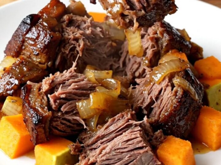 A close-up of a tender chuck roast with butternut squash in a slow cooker, featuring a rich honey balsamic glaze.