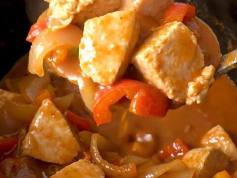 A close-up view of Crockpot Tex-Mex Chicken Guisada in a black slow cooker insert