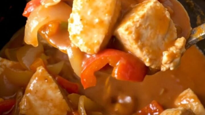 A close-up view of Crockpot Tex-Mex Chicken Guisada in a black slow cooker insert