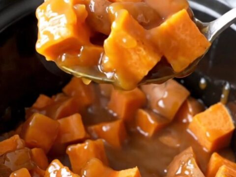 A close-up of tender, bright orange sweet potato chunks mixed with pineapple in a rich