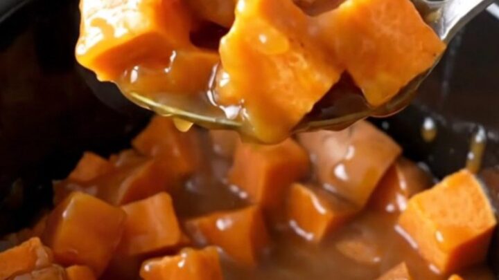 A close-up of tender, bright orange sweet potato chunks mixed with pineapple in a rich