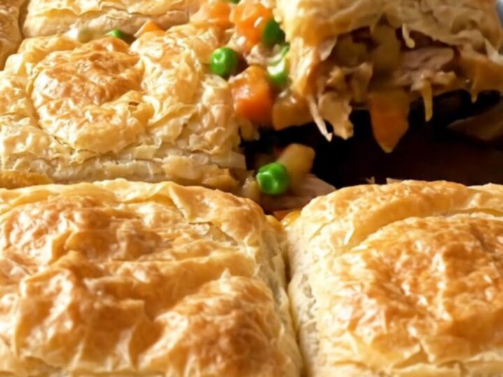 A golden, crispy sheet pan turkey pot pie with visible chunks of turkey and vegetables.