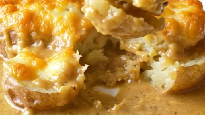 A slow cooker filled with layers of thinly sliced potatoes and melted golden smoked gouda cheese.