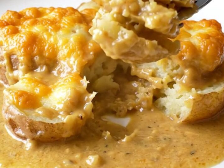 A slow cooker filled with layers of thinly sliced potatoes and melted golden smoked gouda cheese.
