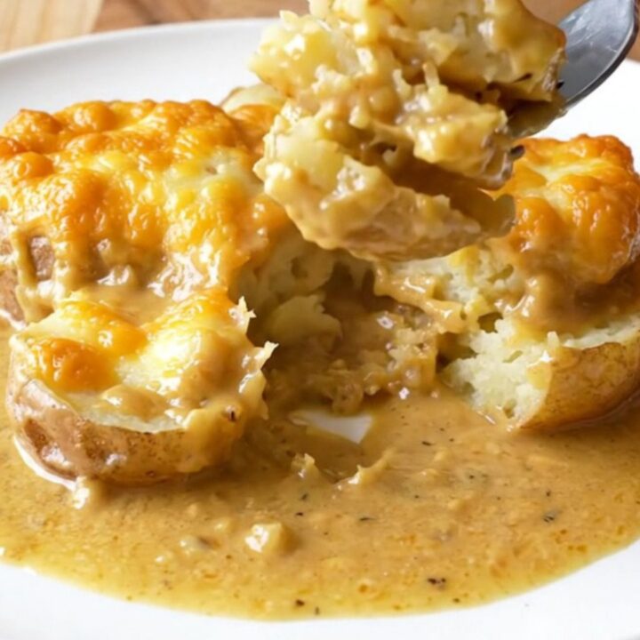 A slow cooker filled with layers of thinly sliced potatoes and melted golden smoked gouda cheese.