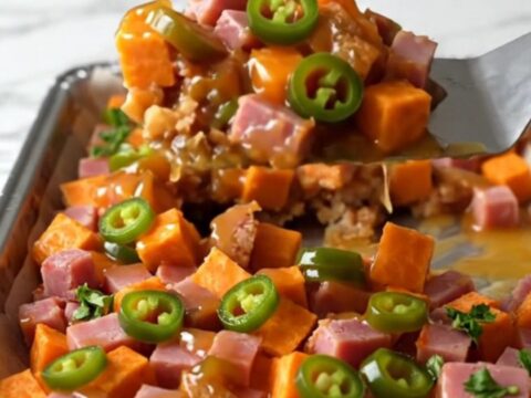 A sheet pan filled with golden roasted sweet potato cubes and browned diced ham
