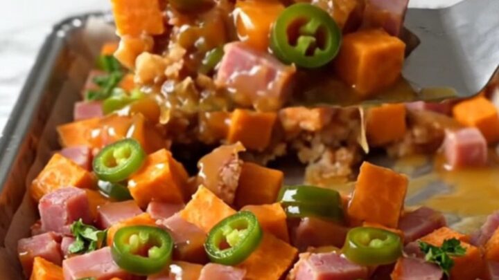 A sheet pan filled with golden roasted sweet potato cubes and browned diced ham