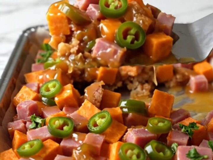 A sheet pan filled with golden roasted sweet potato cubes and browned diced ham