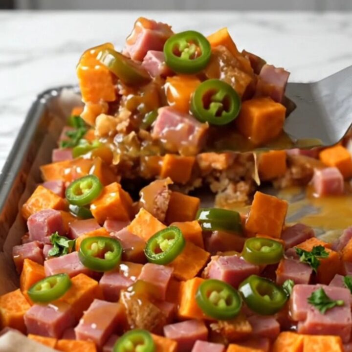 A sheet pan filled with golden roasted sweet potato cubes and browned diced ham