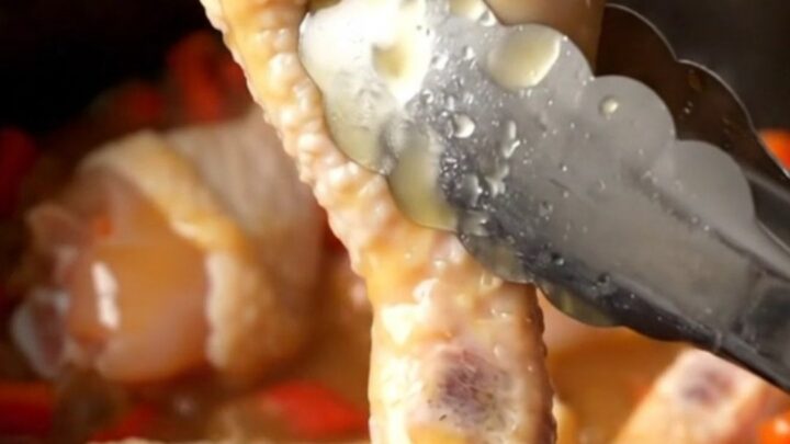 A close-up of honey habanero chicken drumettes in a slow cooker, glazed in a thick, amber, spicy honey sauce.