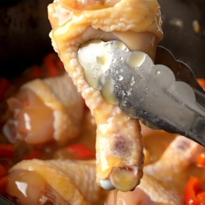 A close-up of honey habanero chicken drumettes in a slow cooker, glazed in a thick, amber, spicy honey sauce.