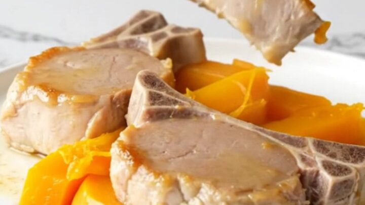 A plate of tender cooked pork loin and soft acorn squash wedges with a light maple glaze.